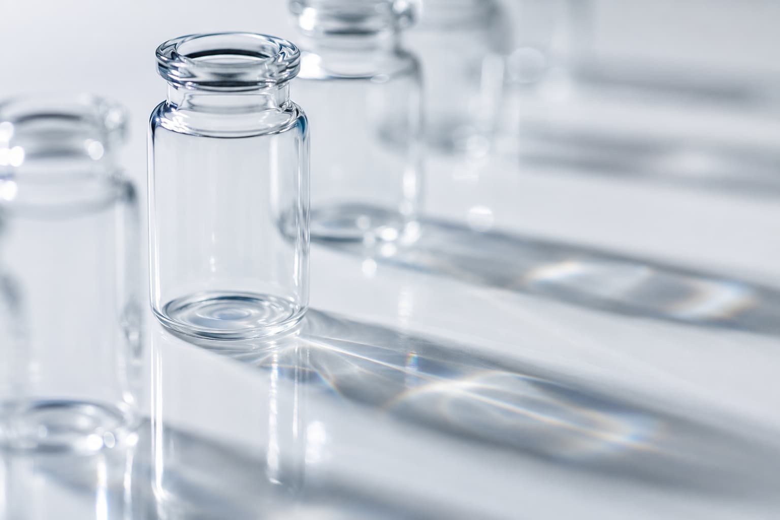 Light refracting through a row of empty borosilicate glass vials